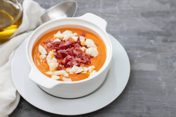 istock Typical Spanish soup salmorejo cream with ham and egg in white bowl on ceramic background. Top view. 1202739502