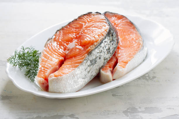 istock fresh salmon with herbs on white dish on ceramic background 1202740159