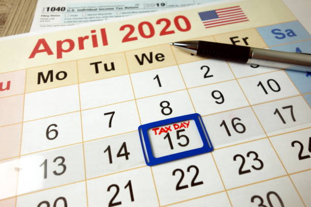 día de impuestos marcado en el calendario mensual de abril de 2020 con formulario 1040 - calendar tax april day fotografías e imágenes de stock