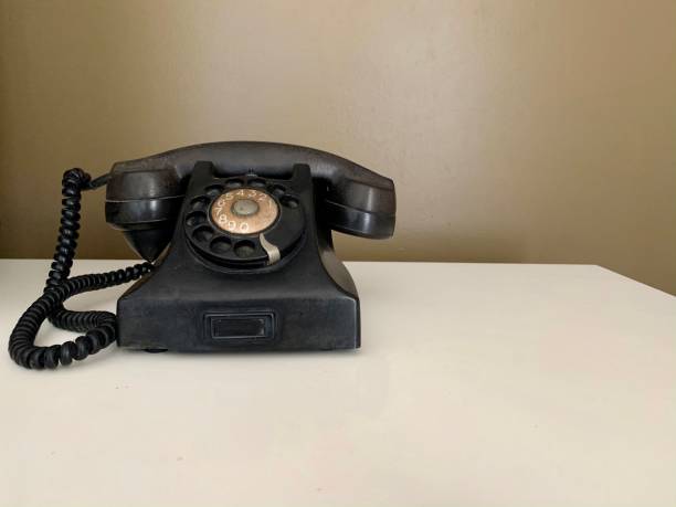 istock Black analog phone on brown background 1202742504
