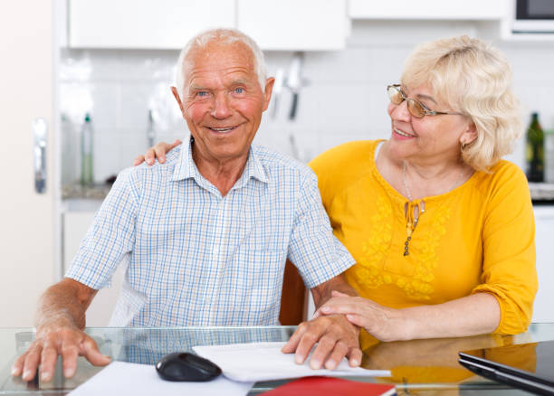 istock Happy mature couple with documents sitting at table in home 1202742752