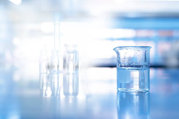 istock glass beaker in blue science chemistry laboratory background 1202742904