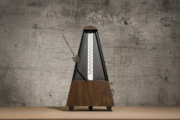 analog metronome, isolated against a concrete background stock photo