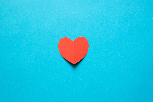 Red heart shaped paper on blue background;Valentine day card concept