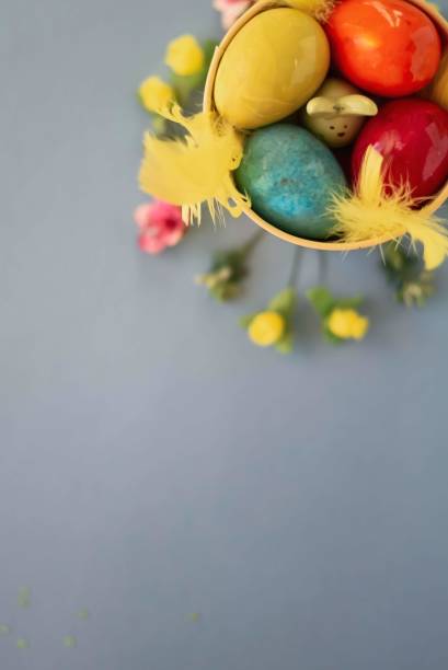 istock Colored easter eggs in a yellow bucket on a blue background 1202748634