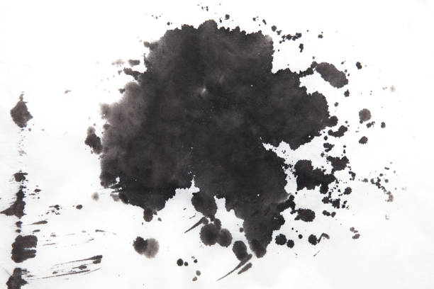 Green blot on a black background. Spots of paint on a piece of paper.