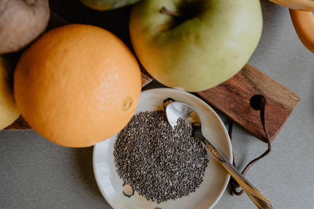 Close-up of chia seeds, orange and apple on the kitchen counter