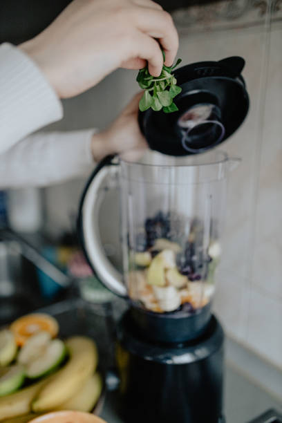 istock Woman putting corn salad in blender to make smoothie 1202752170