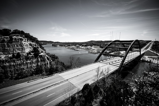 Black and White , monochrome , arch suspension bridge in Austin Texas USA  -Pennybacker Bridge landmark of Austin Texas Cliffs and highway
