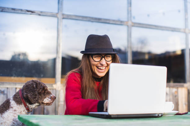 istock woman working with cute dog on laptop 1202752325