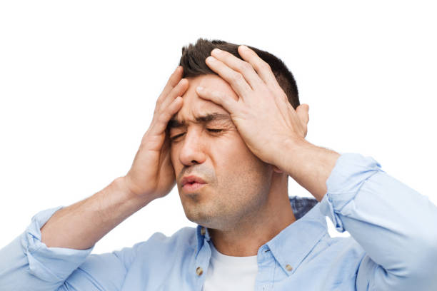 istock unhappy man with closed eyes touching his forehead 1202752501