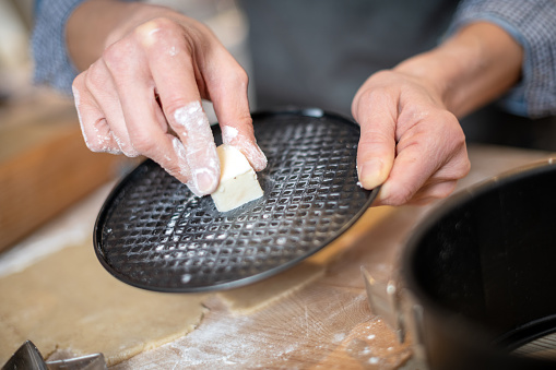 Woman baking at home: Baking tin butter preparation