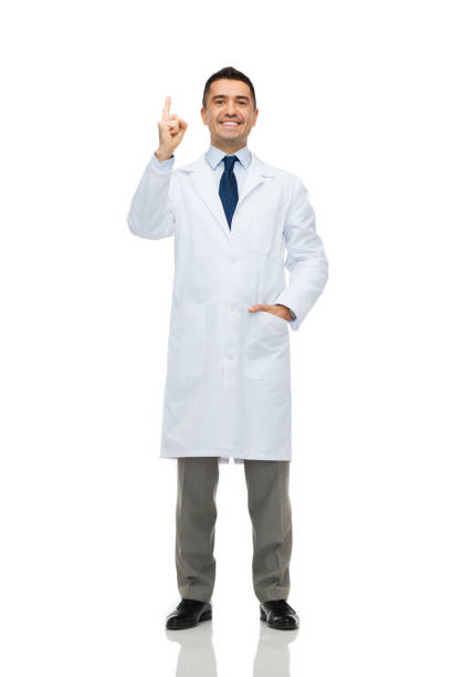 Studio shot of young happy bald muscular man doctor smiling while wearing protective glasses with arms crossed vertical shot