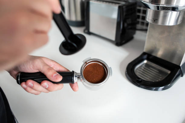 istock Guy prepare delicious aromatic coffee in a coffee machine. A simple way to make coffee 1202755060