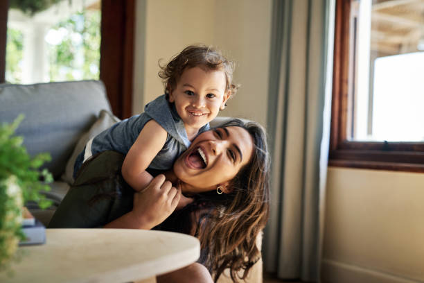 He's such a happy little soul Cropped portrait of an affectionate young single mother spending time with her little son in their living room at home mom and baby eye contact stock pictures, royalty-free photos & images