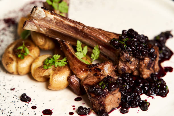 istock Lamb ribs with baked potatoes on a white plate, close-up. 1202760642