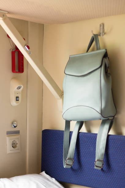 istock blue backpack hanging in a train compartment. women's bag for traveling on a hook 1202762436