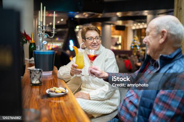 Happy Senior Couple Enjoying Evening At Hotel Bar Stock Photo - Download Image Now - Senior Adult, Cocktail, Winter