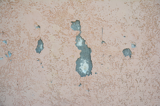 Repair cracks and holes in house insulation wall with stucco. Repairing a  drywall hole. Damaged plaster insulation wall outdoor.