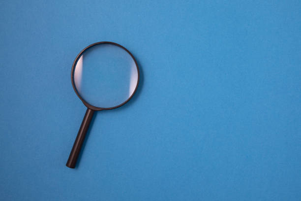 istock Magnifying Glass on Blue Background 1202769495