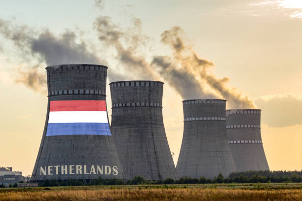 istock Nuclear plant chimneys displaying flag of Netherlands with according text. Energy pollution accidents in a country concept. 1202769585