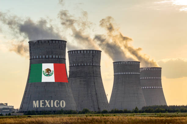 istock Nuclear plant chimneys displaying flag of Mexico with according text. Energy pollution accidents in the country concept. Power production and generation from atomic energy. 1202769735