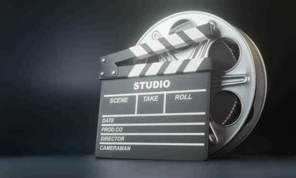 istock Film reel with clapperboard on black background 1202770086