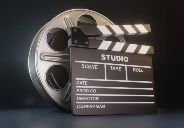 istock Film reel with clapperboard on black background 1202770094