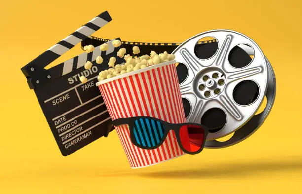 Photo of Flying popcorn, 3D glasses, film reel and clapboard on a yellow background