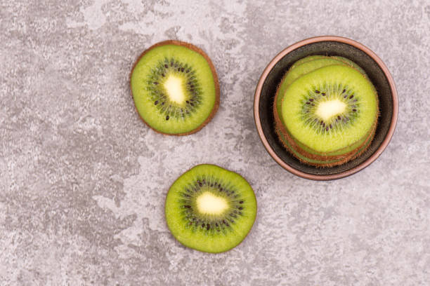 istock Kiwi slices on a grey textured background, empty copy space 1202770339