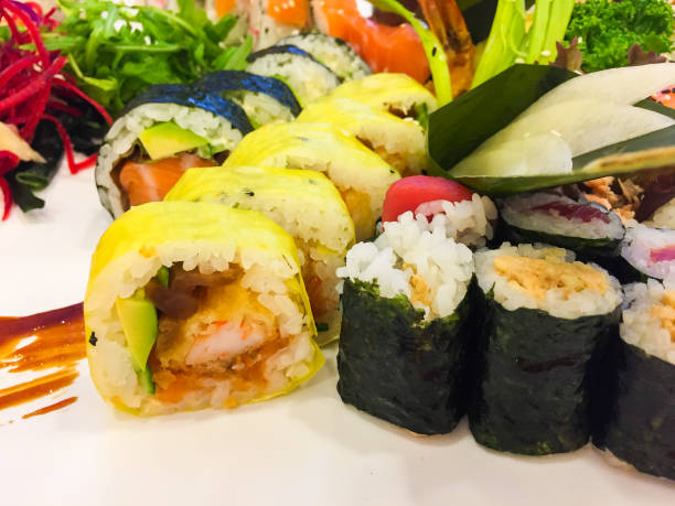 istock Variety of sushi rolls on a white plate 1202771084