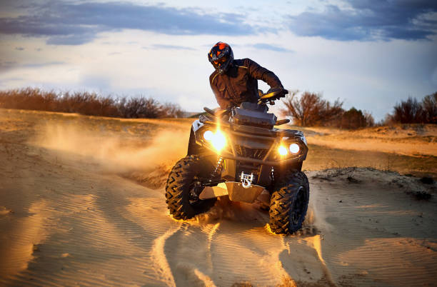 istock Racing powerful quad bike on the difficult sand in the summer. 1202771205