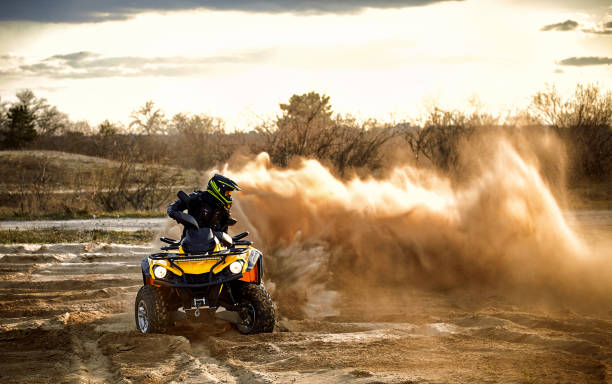 istock Racing powerful quad bike on the difficult sand in the summer. 1202771278