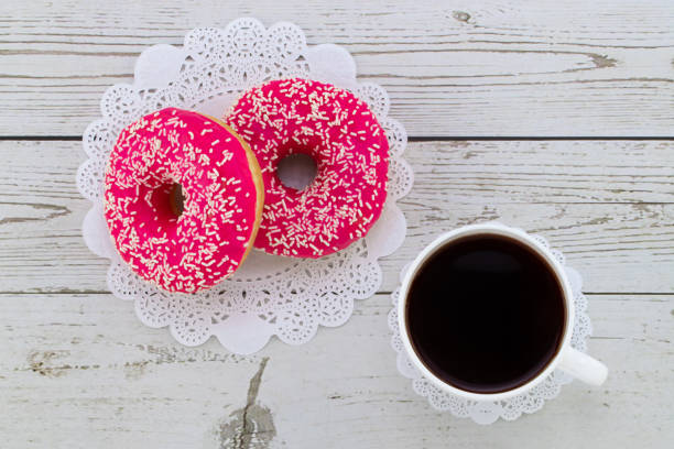 istock Donuts and coffee on a white wood background, top view 1202772665