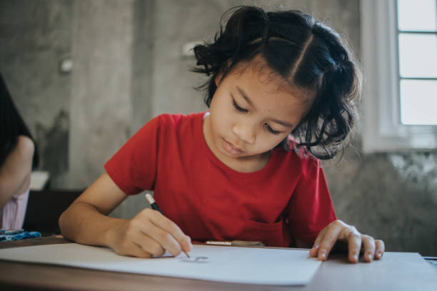 istock Concentration of Thai girl and friends while doing drawing at the classroom 1202777761