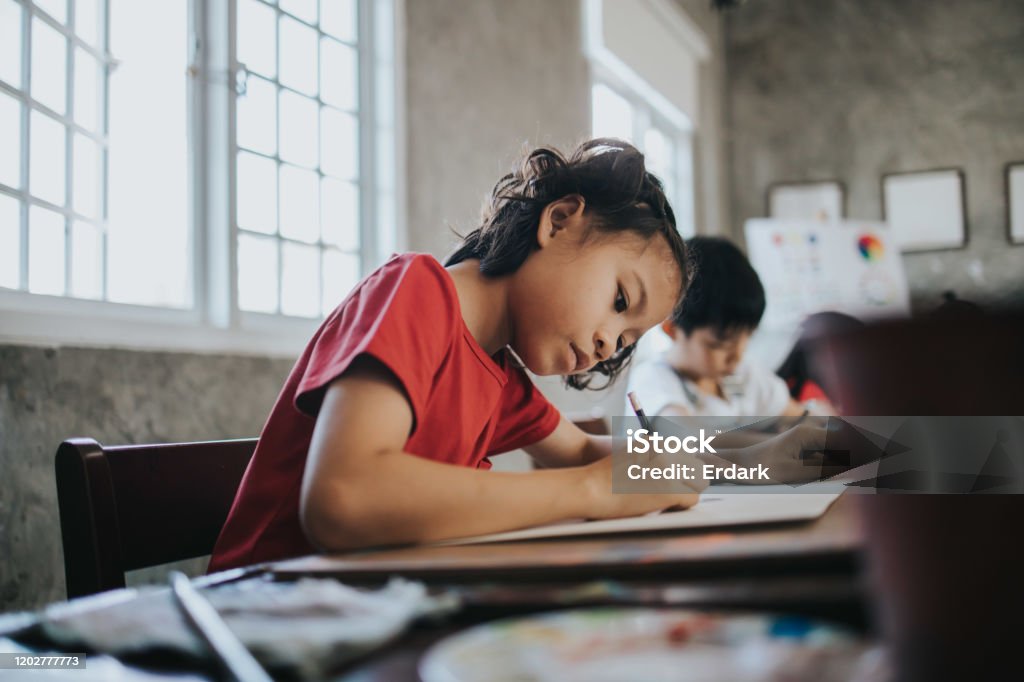 Thai children concentrate to draw idea and imagination with positive emotion while learning at the school Thai school children enjoy doing art class at school Drawing - Activity Stock Photo
