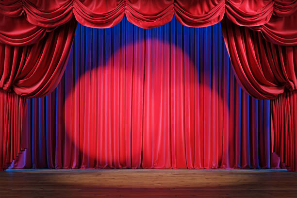 istock Empty theater stage with red velvet curtains and spotlights. 1202781138