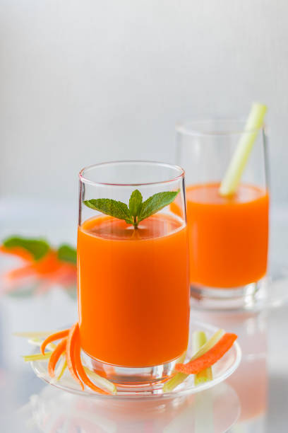 Freshly squeezed carrot juice with celery, vertical orientation stock photo