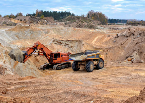 istock Excavator loading sand in the dump truck in open-pit mining 1202783998