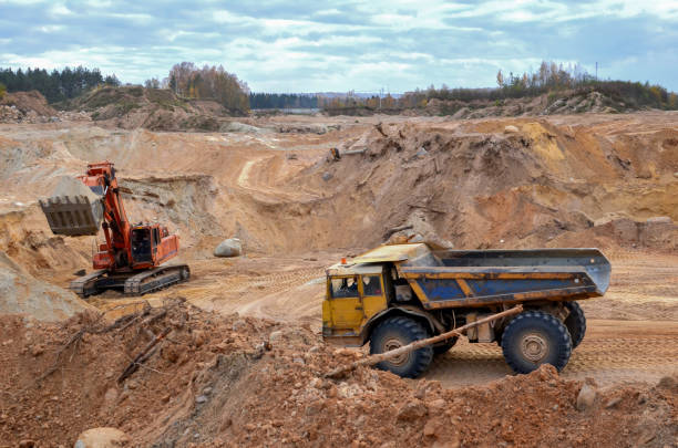 istock Excavator loading sand in the dump truck in open-pit mining 1202784001