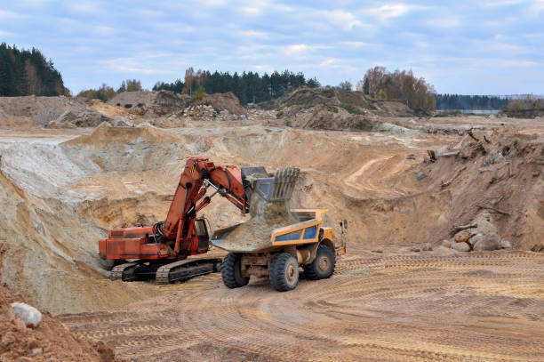 istock Excavator loading sand in the dump truck in open-pit mining 1202784108