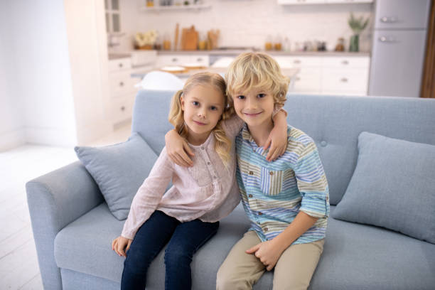 istock Two blod kids sitting next to each other and hugging 1202784232
