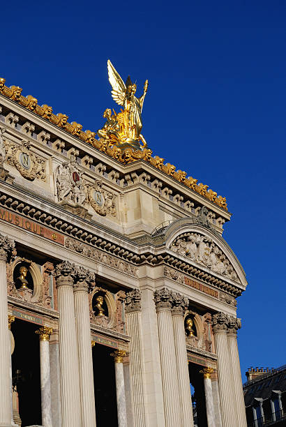Paris, France - October 25, 2009: A busy Avenue de l'Opera in downtown Paris. The Palais Garnier or Paris Opera House makes an impressive architectural statement at the end of the avenue while the street below is filled with typical daytime pedestrian and motor vehicle traffic.