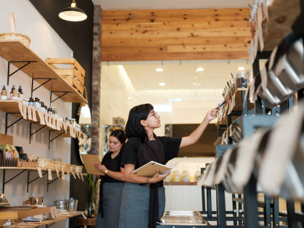istock Young employees doing inventory with notebooks in store 1202789059