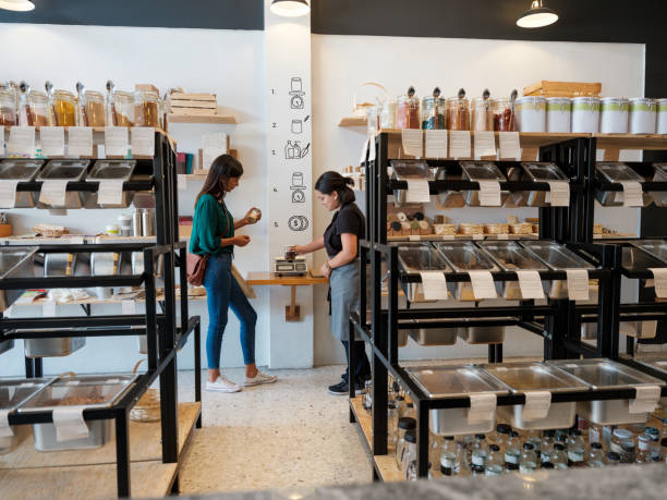 istock Latin shop assistant putting products in weight scale 1202789091