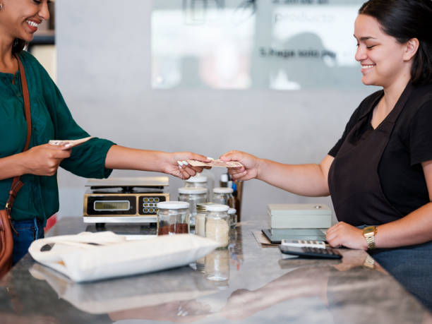 istock Happy female costumer paying at counter and smiling 1202789092