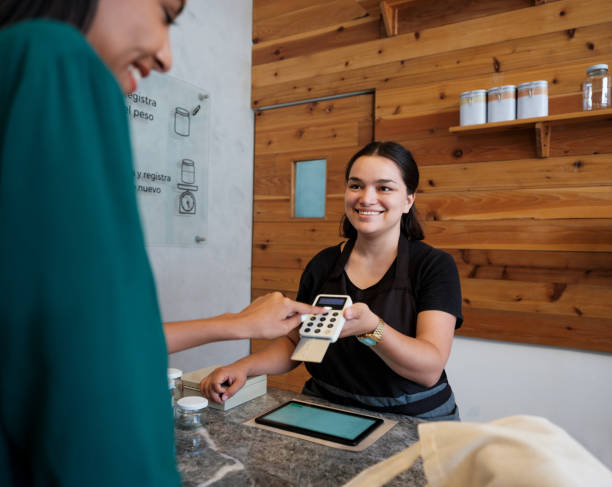 istock Female costumer pressing PIN number in payment terminal 1202789103