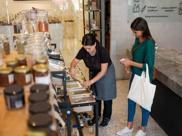 istock Latin seller serving costumer's containers with product 1202789147
