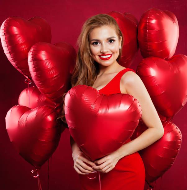 Portrait of beautiful young woman with red heart balloons, celebration and holiday concept Portrait of beautiful young woman with red heart balloons, celebration and holiday concept valentine s day holiday stock pictures, royalty-free photos & images