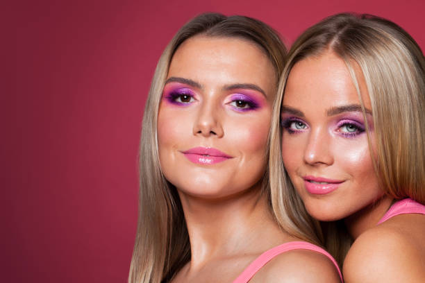 istock Beautiful smiling women models with makeup on pink 1202789449
